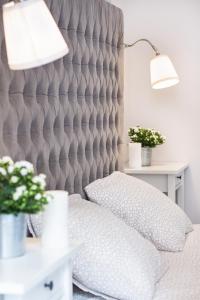 a bed with a grey padded headboard and a lamp at My Old Town Gdańsk - Apartamenty Długa 56 in Gdańsk