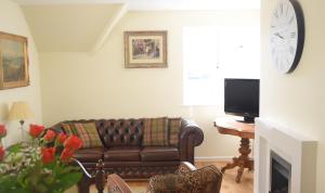 a living room with a couch and a television at Staddlestones Broadway in Broadway