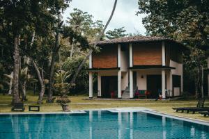 a house with a swimming pool in front of it at Talalla Retreat in Talalla South
