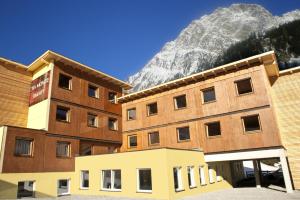 two buildings with a mountain in the background at Hotel Tia Smart Natur in Kaunertal