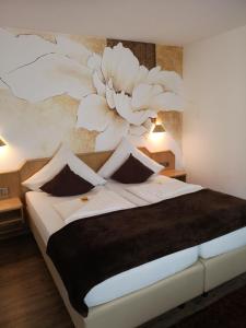 a bedroom with a large bed with a painting on the wall at Hotel DreiKönig & Restaurant SeeGourmet in Hagnau