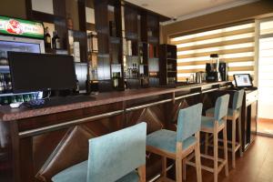 eine Bar mit Stühlen und einem Computer auf dem Tresen in der Unterkunft B&B Lake House Hotel in Yusufkhona