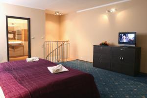 a bedroom with a purple bed and a television at Sportpenzion Pohoda in Pilsen +37 photos