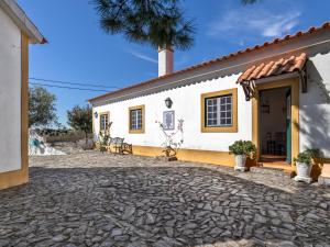 a house with a stone driveway in front of it at Monte Velho Country House in Montargil