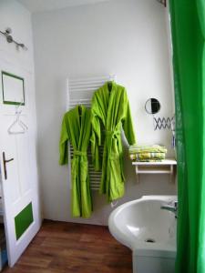 een badkamer met een groene badjas aan een muur bij Rainmühle in Mariánské Lázně