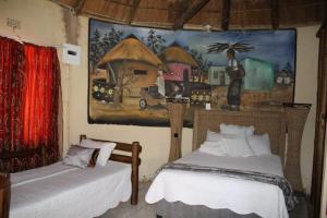 Un dormitorio con dos camas y un cuadro en la pared. en Gae Lodge, en Ganyesa