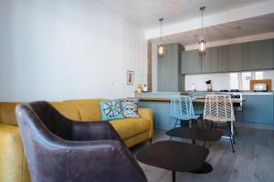 ein Wohnzimmer mit Couch und Tisch und eine Küche in der Unterkunft Apartamento Alameda in Sevilla + 15 Fotos