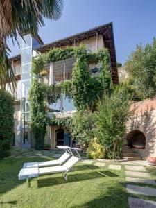 a building with two white benches in front of it at "Luisa's Smile" in Guarene