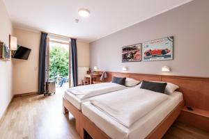 a bedroom with two beds and a large window at JUFA Hotel Seckau - Self Check-in in Seckau +23 photos
