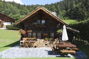 a log cabin with an umbrella in front of it at Le P'ti Tzi-Mé in Villars-sur-Ollon