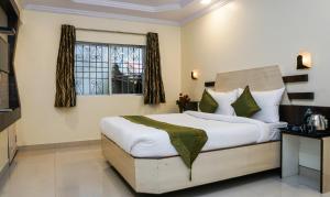 een slaapkamer met een groot bed en een raam bij Treebo Trend Hillway Inn Main Market in Mahabaleshwar