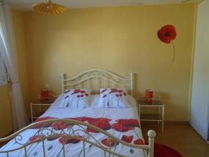 1 dormitorio con 1 cama con una flor roja en la pared en ESCALE à FORT-BLOQUE 56 en Ploemeur