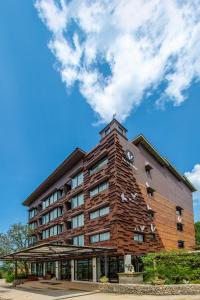 a large brick building with a sky in the background at The Farm House Hotel Ranong in Ranong