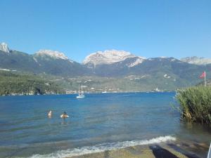 duas pessoas a nadar num lago com montanhas ao fundo em Barthoux em Seythenex