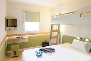 a bedroom with a bunk bed and a television at ibis budget Duesseldorf Willich in Willich