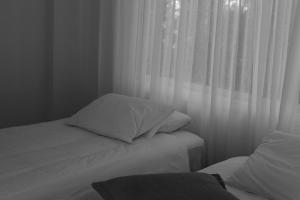 a black and white photo of a bed with a window at Olosuites in Limassol