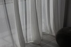 a white curtain sitting on top of a tiled floor at Olosuites in Limassol