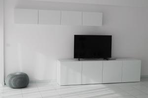 a flat screen tv sitting on top of a white cabinet at Olosuites in Limassol