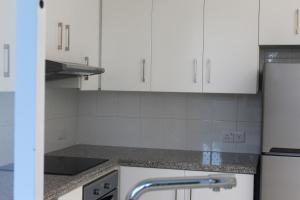 a kitchen with white cabinets and granite counter tops at Olosuites in Limassol