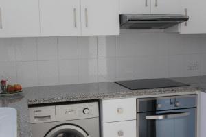 a white kitchen with a dishwasher and a washer at Olosuites in Limassol