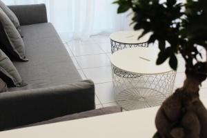 a living room with a couch and a table with a plant at Olosuites in Limassol