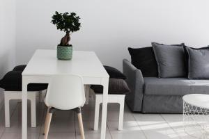 een witte tafel en stoelen in een woonkamer met een bank bij Olosuites in Limassol