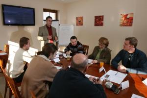 a group of people sitting around a table in a meeting at Sportpenzion Pohoda in Pilsen