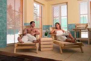 a man and a woman sitting in beds at Sportpenzion Pohoda in Pilsen