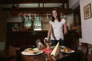 a woman standing in a restaurant with a table with food at Sportpenzion Pohoda in Pilsen