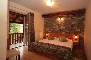 ein Schlafzimmer mit einem Bett und einer Steinmauer in der Unterkunft Domačija Linč in Rodik