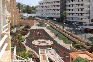 arialer Blick auf einen Innenhof mit einer Uhr in einem Gebäude in der Unterkunft Studioapartment Borinquen in Playa Fañabe