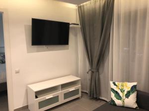 uma sala de estar com uma televisão de ecrã plano na parede em Luxury Apartment Playa del Ingles em Playa del Inglés
