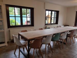 une salle de conférence avec une grande table et des chaises en bois dans l'établissement De Goeferdij vakantiewoning, à Grammont