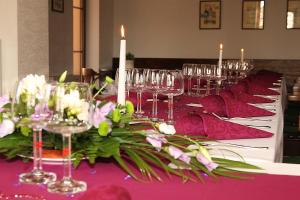 a table with wine glasses and flowers on it at Sportpenzion Pohoda in Pilsen