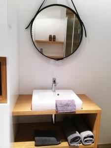 La salle de bains est pourvue d'un lavabo et d'un miroir. dans l'établissement Ambar Apartament, à Gdańsk