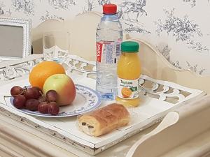 un vassoio con frutta, una bottiglia d'acqua e un succo di frutta di Chambre chez l'habitant a Orsay