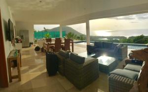 a living room with couches and a table and a pool at Savane Paille in Deshaies