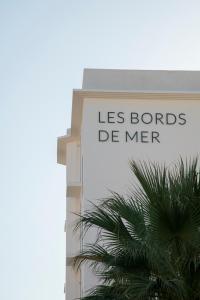 a sign on the side of a building with a palm tree at Les Bords De Mer in Marseille