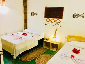 a room with two beds with red flowers on them at Casa Jeri in Jericoacoara +60 photos
