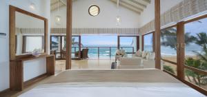 a bedroom with a bed with a view of the ocean at Lucky Elephant Hotel in Hikkaduwa