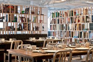 a dining room with tables and chairs and books at amba Taipei Ximending in Taipei