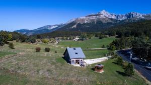 an aerial view of a house on a hill with mountains at Chalet du champ Martel in Villard-de-Lans