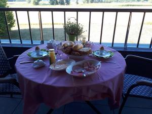 una mesa con un mantel púrpura con comida. en Klein Cambron, en Hulst