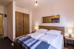 sypialnia z dużym łóżkiem z drewnianym zagłówkiem w obiekcie udanypobyt Apartamenty Czorsztyn Panorama w Czorsztynie