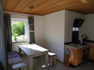 una pequeña cocina con mesa y ventana en FeWo KeDo en Neukirchen vorm Wald