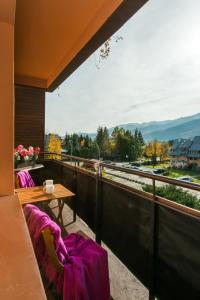 a balcony with two chairs and a table and a view at Apartament Rodzinny in Kościelisko