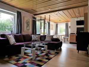 uma sala de estar com um sofá roxo e uma mesa em FeWo KeDo em Neukirchen vorm Wald