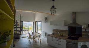 a kitchen with a table and a dining room at L'Alphonsine in Veyre-Monton