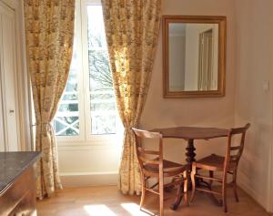 a dining room table and chairs in front of a window at Château des Tertres in Onzain