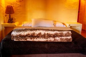 a bedroom with a bed with a faux fur blanket on it at Hotel Posada Primavera in San Cristóbal de Las Casas